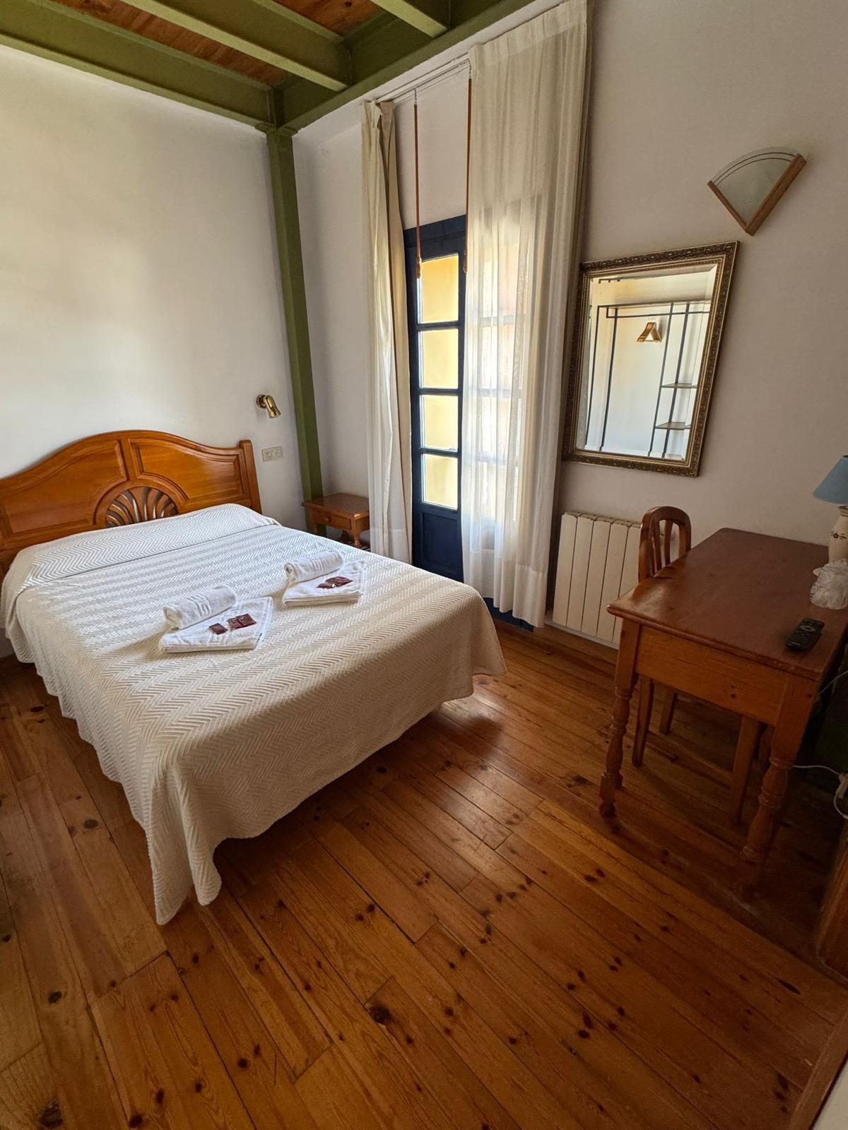 Habitación matrimonio luminosa con suelo de madera y balcón Hotel Cuevas del Mar
