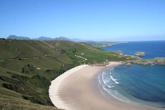 Playa virgen de Torimbia en Llanes Asturias en herradura rodeada de praderas verdes